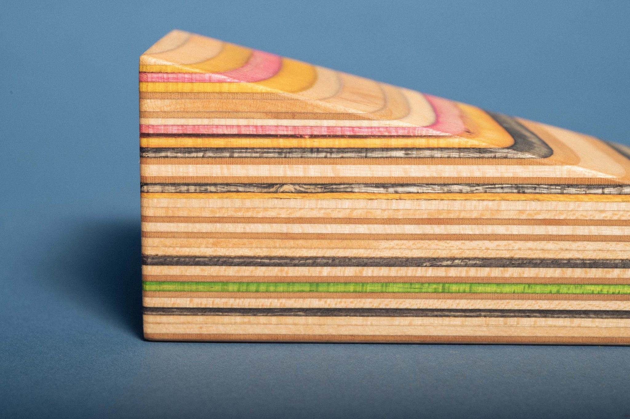 Close-up of the Door Stop, showing the multicolored layers of recycled skateboard wood
