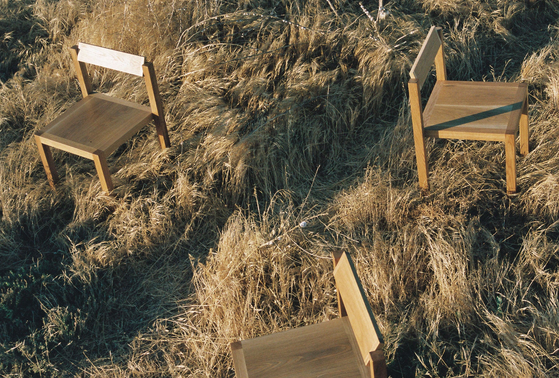 Three Anything Chairs arranged in grassland