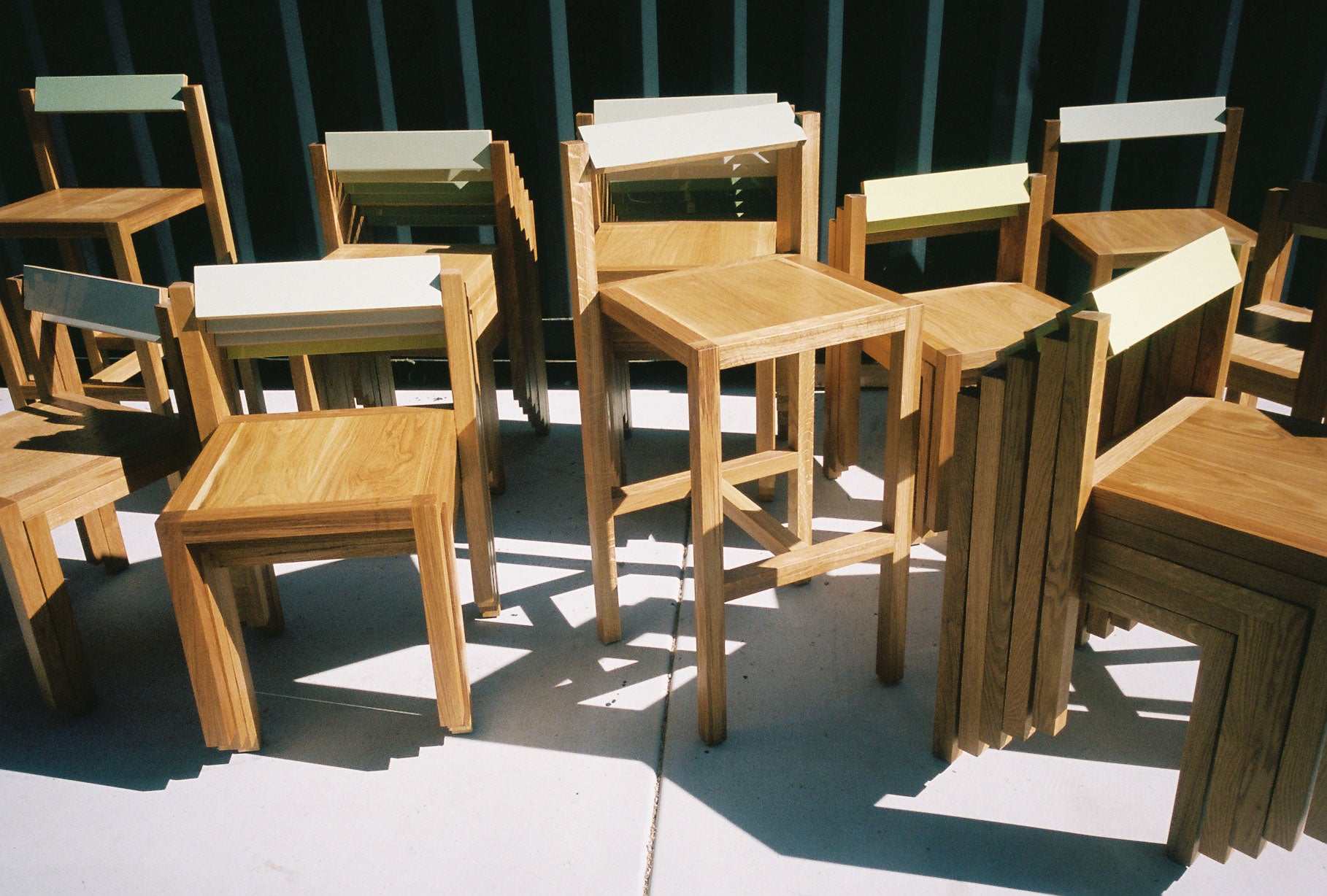 Close-up shot of many Anything Chairs and Anything Counter Stools stacked and arranged out on the patio.