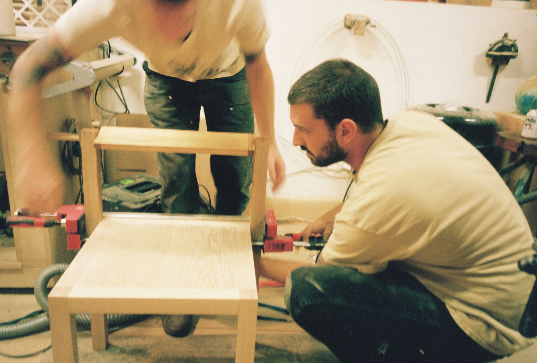 Two people assemble the Anything Chair in the workshop.
